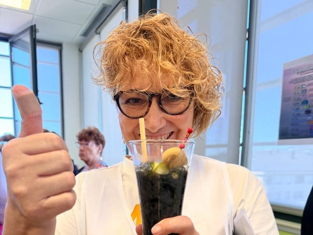 Participante con una bebida herbal preparada en el taller de coctelería