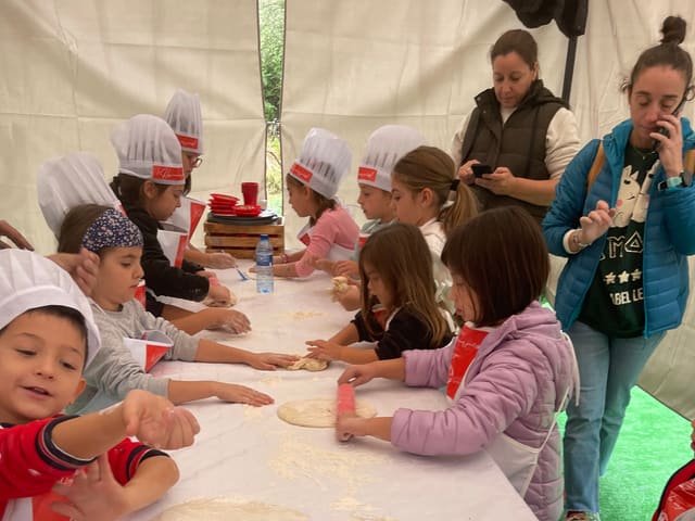 Niñas y niños amasando en un taller de cocina infantil