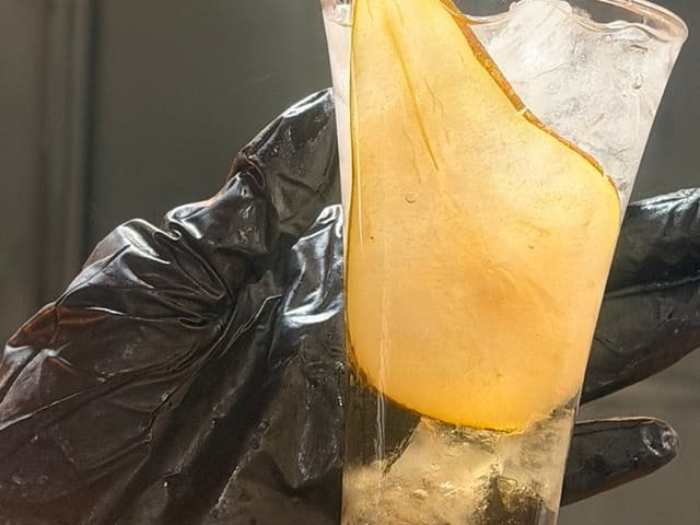 Detalle de un cóctel decorado con lámina de pera
