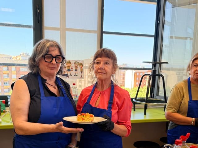 Dos participantes con el plato de arroz recién emplatado