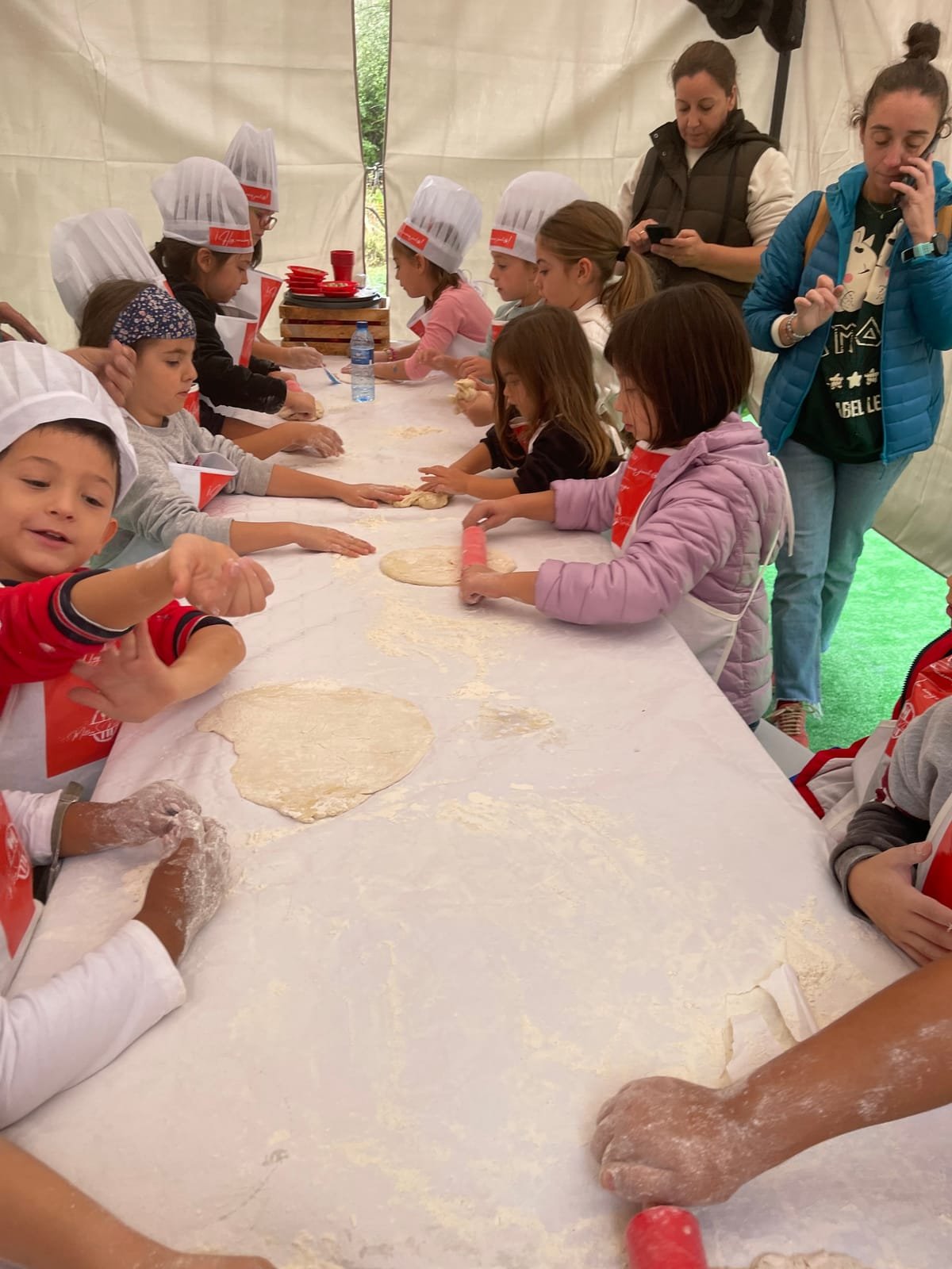 Niñas y niños amasando en un taller de cocina infantil